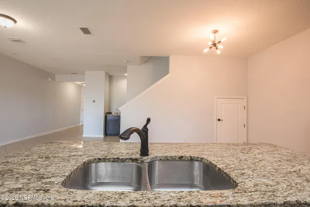 a kitchen with a sink a faucet and chandelier