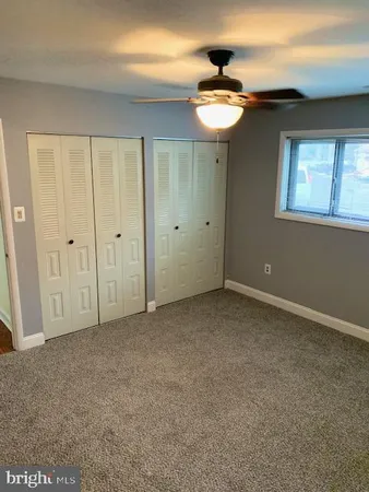 a view of an empty room with window and cabinet