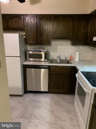a kitchen with stainless steel appliances a stove a sink and a refrigerator