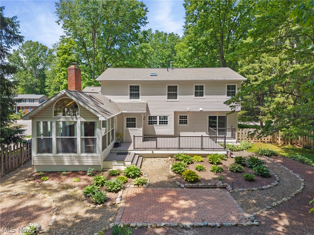 3871 Greentree Road Stow, OH 44224 - Photo 2 of 50 Rear exterior featuring a multi-level deck with black railings, a sunroom with an arched window, and a red brick chimney