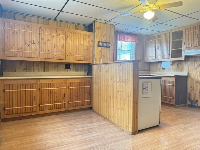 a kitchen with cabinets and wooden floor