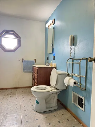 a bathroom with a toilet sink and mirror
