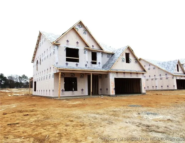 a front view of a house with large trees