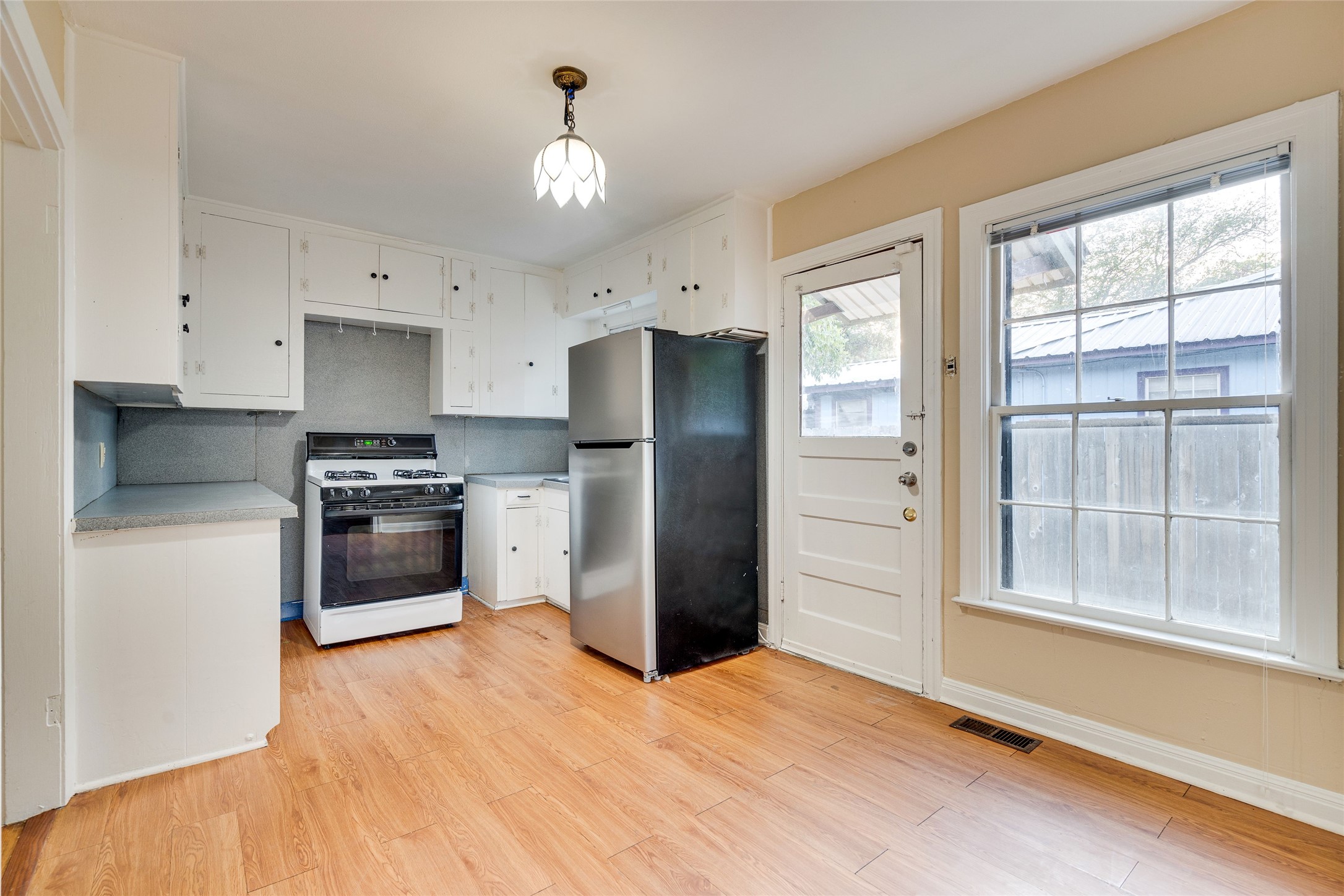 1011 East 49th Street Austin, TX 78751 - Photo 11 of 35 a kitchen with a refrigerator and a stove top oven