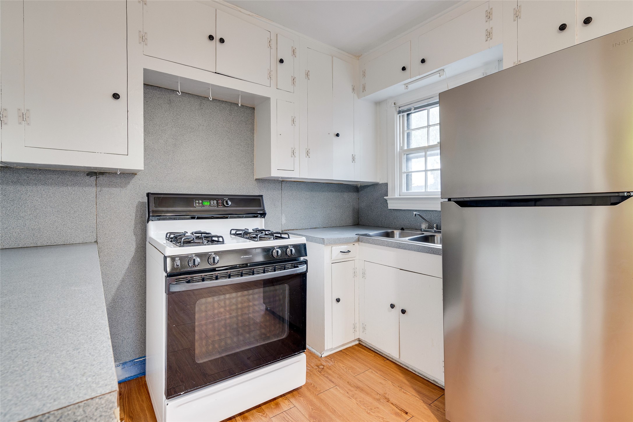 1011 East 49th Street Austin, TX 78751 - Photo 12 of 35 a kitchen with cabinets appliances and wooden floor
