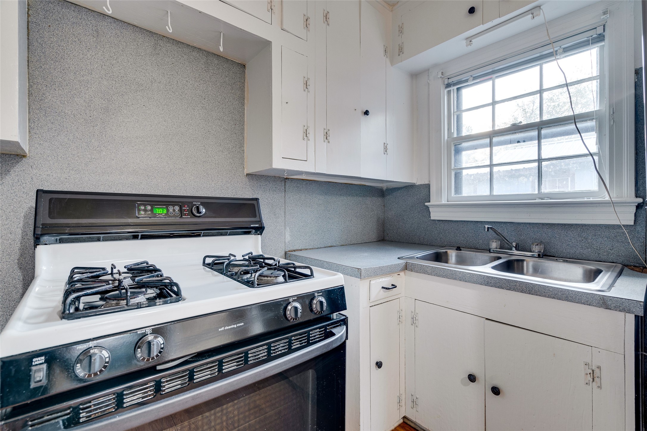 1011 East 49th Street Austin, TX 78751 - Photo 14 of 35 a kitchen with a stove a sink and a window