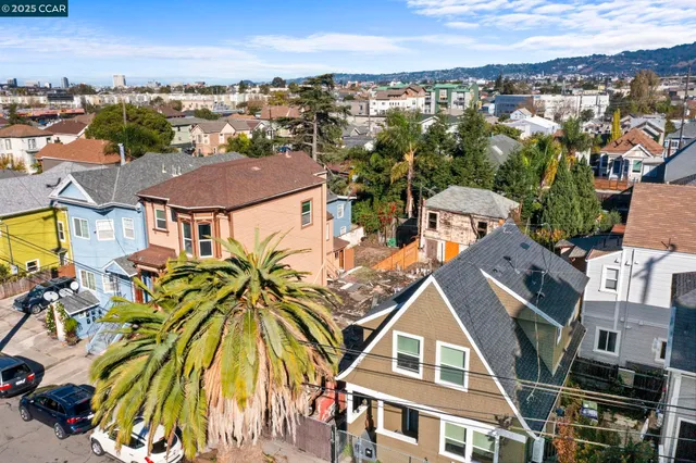 an aerial view of residential houses with outdoor space and ocean view