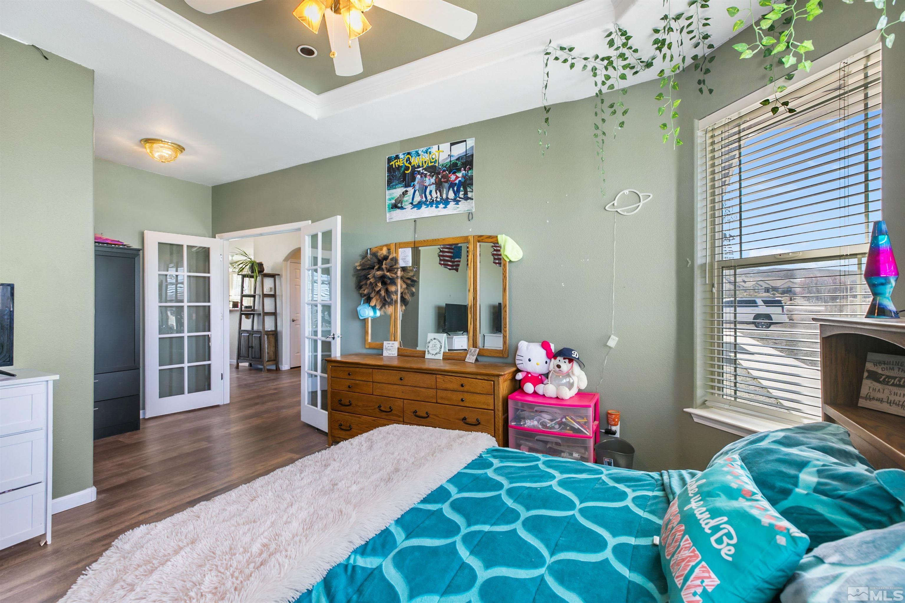 1095 Sage Street Fernley, NV 89408 - Photo 16 of 37 a bedroom with a bed mirror and a chandelier