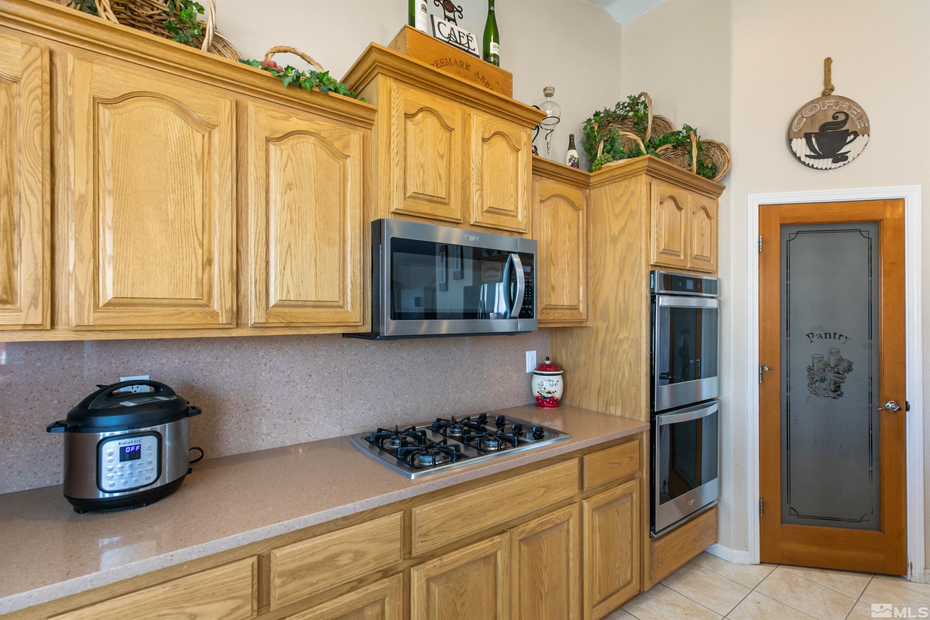 1095 Sage Street Fernley, NV 89408 - Photo 26 of 37 a kitchen with stainless steel appliances granite countertop a refrigerator and a stove top oven
