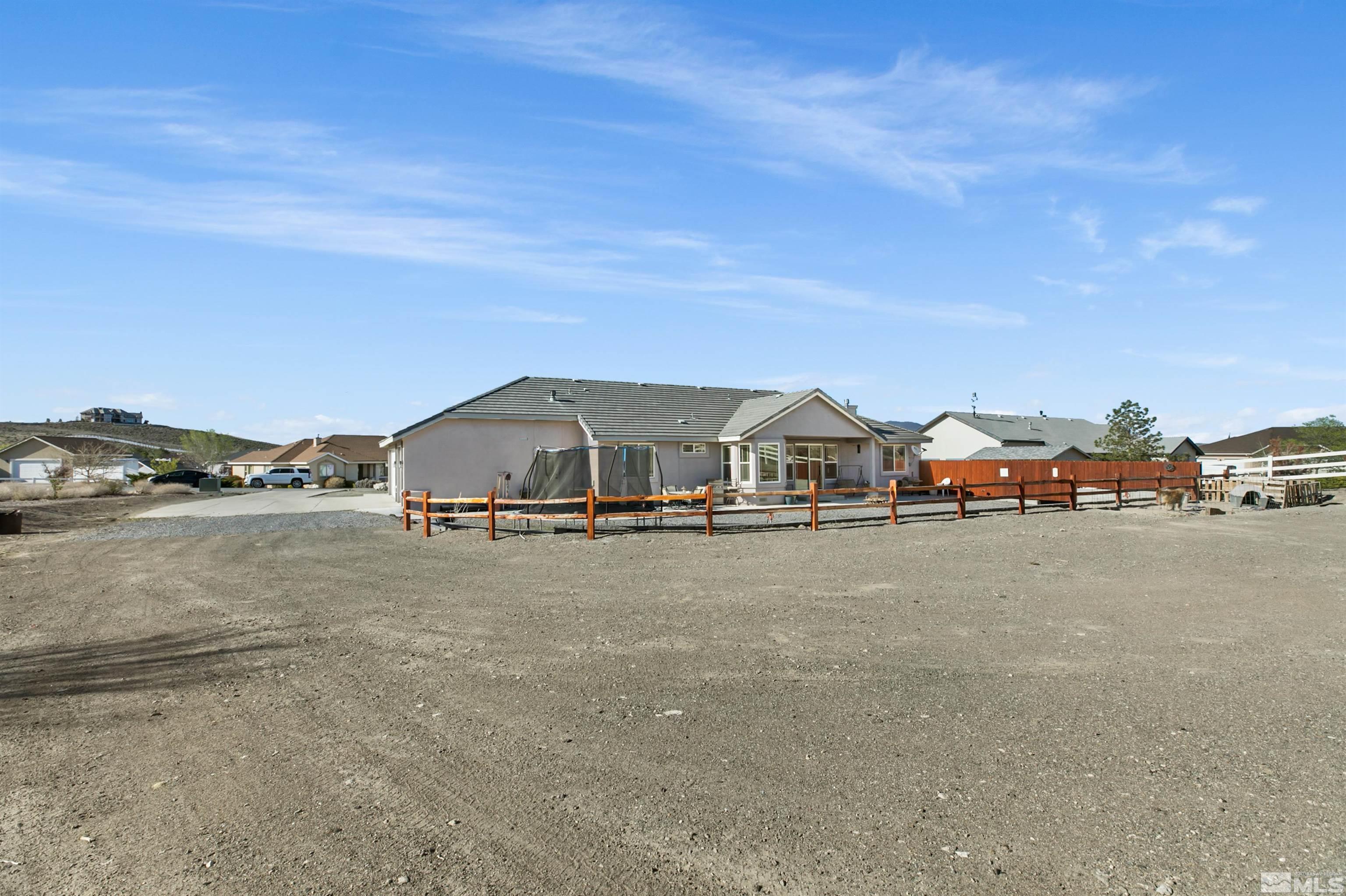 1095 Sage Street Fernley, NV 89408 - Photo 10 of 37 a big house with a big yard and large trees