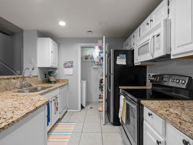 900 Bitner Road, Unit D 34 Park City, UT 84098 - Photo 8 of 25 Kitchen featuring white appliances, light stone countertops, white cabinetry, light tile patterned flooring, and recessed lighting