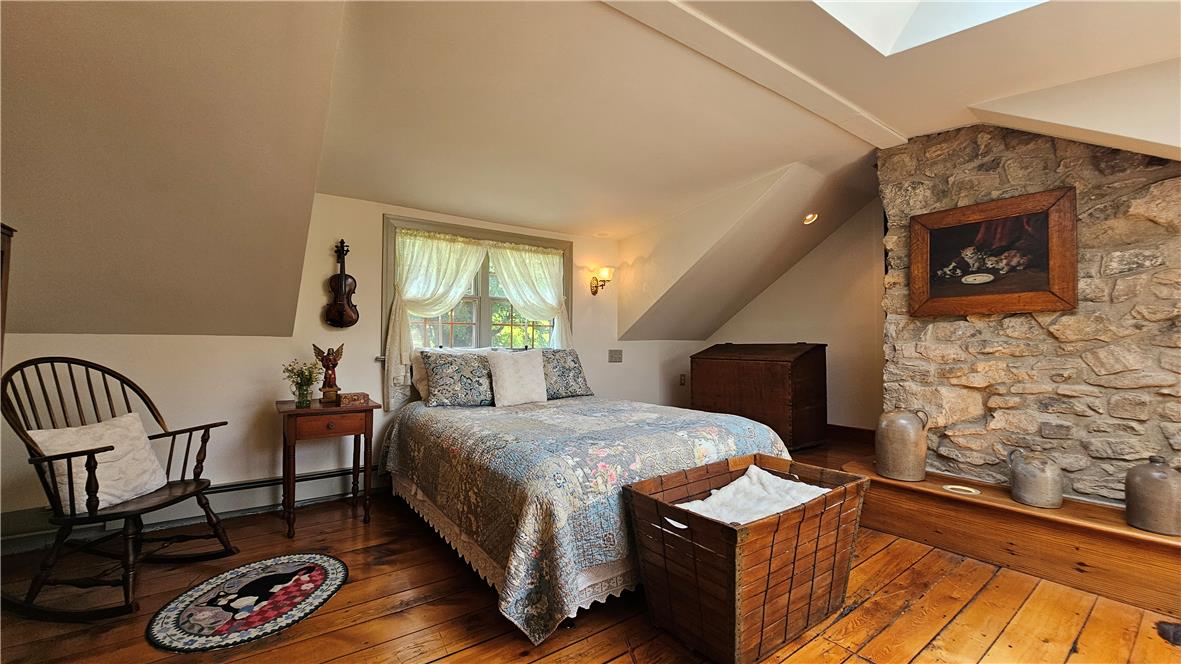 585 Buttermilk Road Hellertown, PA 18055 - Photo 28 of 82 Authentic stone walls and warm wood flooring define this charming, sun-drenched sleeping area.