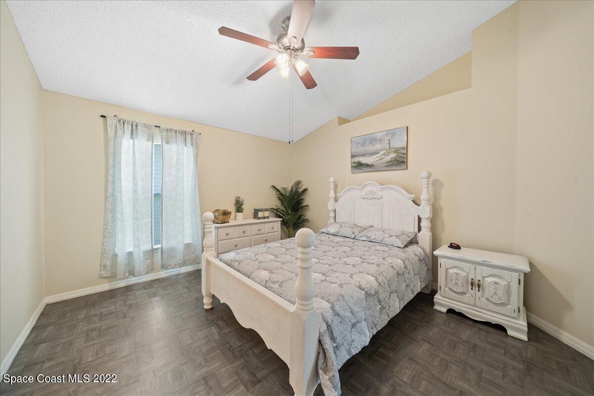 2177 Redwood Circle Palm Bay, FL 32905 - Photo 12 of 30 a bedroom with a bed and a chandelier
