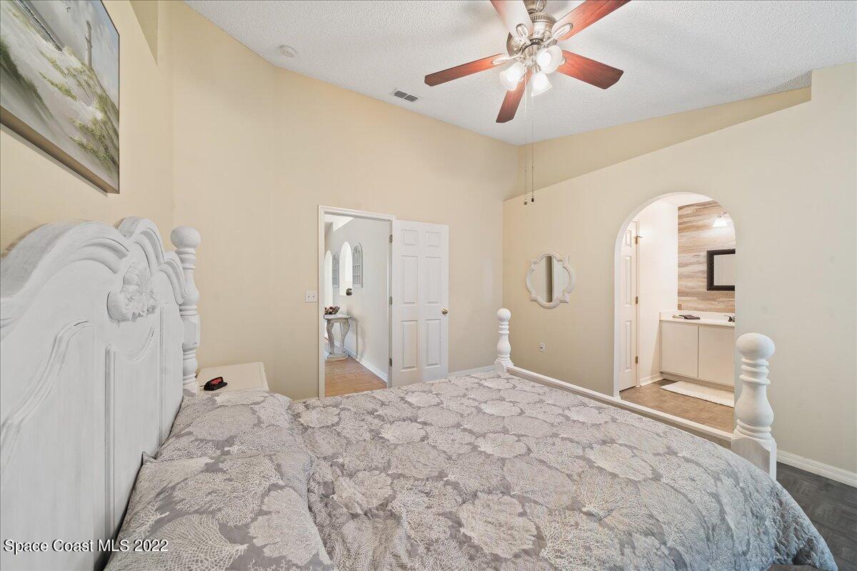 2177 Redwood Circle Palm Bay, FL 32905 - Photo 14 of 30 a bedroom with a bed and a chandelier