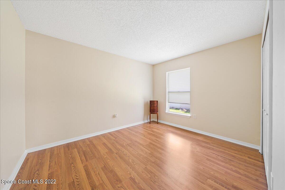 2177 Redwood Circle Palm Bay, FL 32905 - Photo 17 of 30 an empty room with wooden floor and windows
