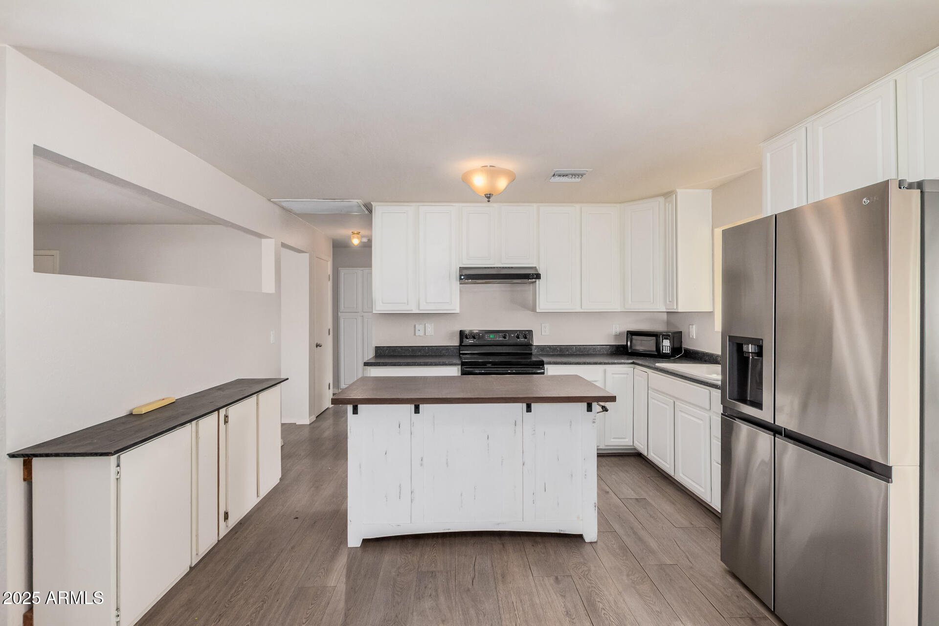 5533 East Decatur Street Mesa, AZ 85205 - Photo 9 of 29 a kitchen with stainless steel appliances a refrigerator a stove and white cabinets