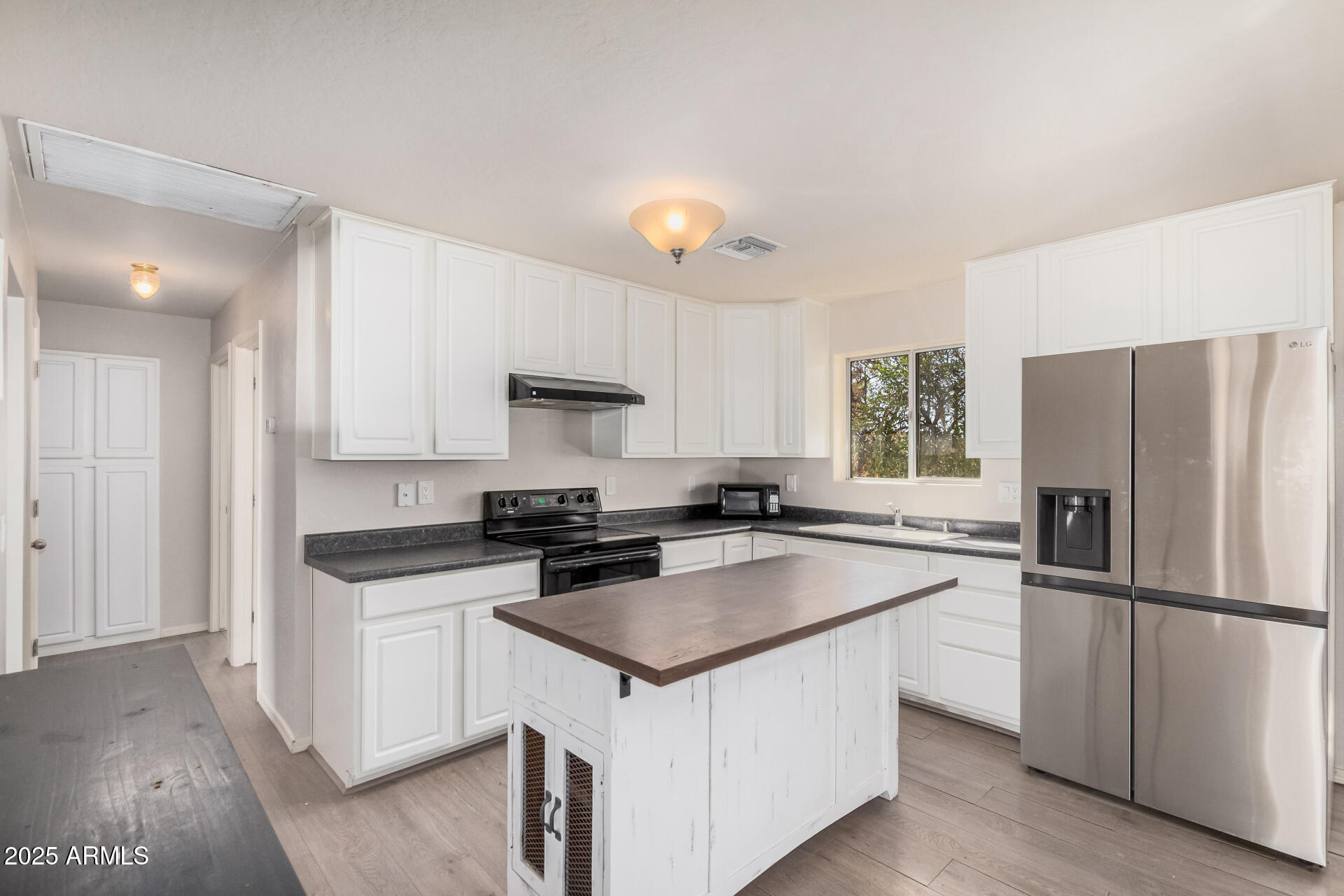5533 East Decatur Street Mesa, AZ 85205 - Photo 10 of 29 a kitchen with a sink a stove a refrigerator a center island and a window