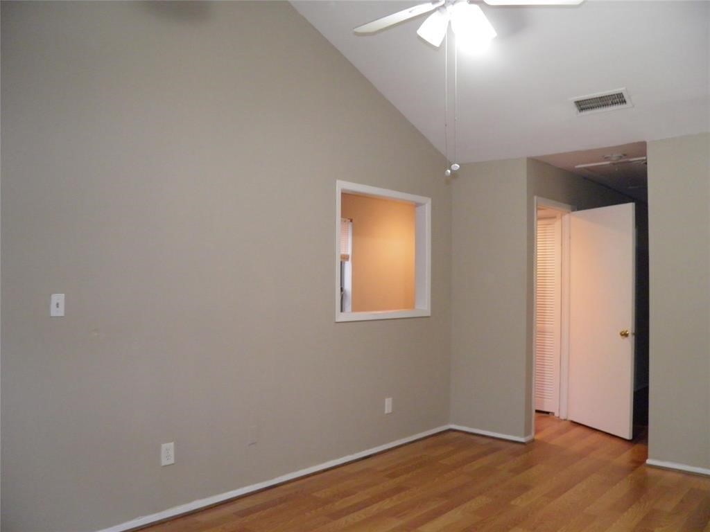 9901 Sharpcrest Street, Unit D1 Houston, TX 77036 - Photo 6 of 8 an empty room with wooden floor and windows