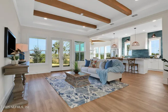 a very nice looking living room with a large window and wooden floor