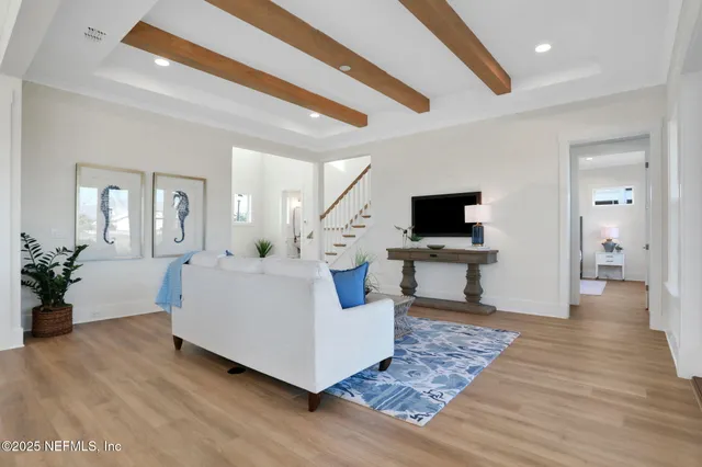 a kitchen with a stove a sink and wooden floor