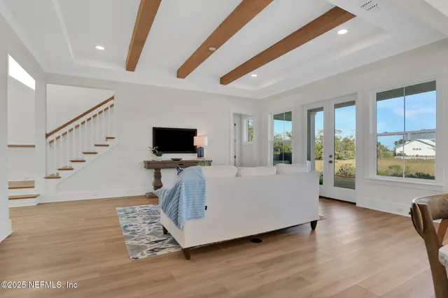 a kitchen with stainless steel appliances granite countertop a stove a sink a microwave a dining table and chairs with wooden floor