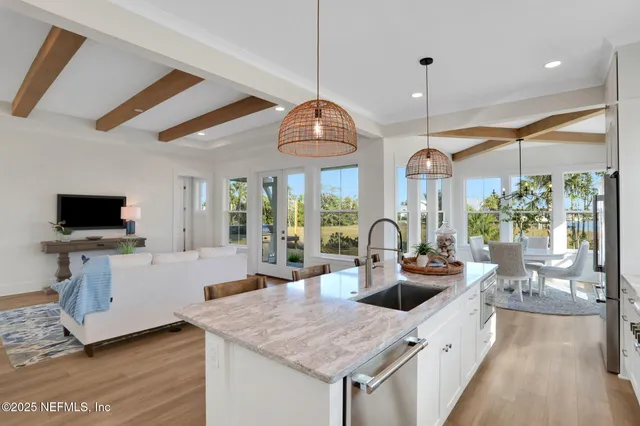 a dining room with furniture a chandelier and wooden floor