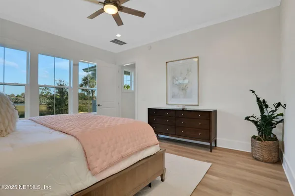 a spacious bedroom with a large bed and a potted plant