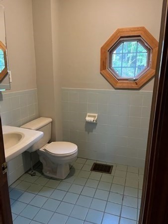 656 Franklin Street, Unit 656 Wrentham, MA 02093 - Photo 8 of 11 a bathroom with a toilet a sink and a mirror