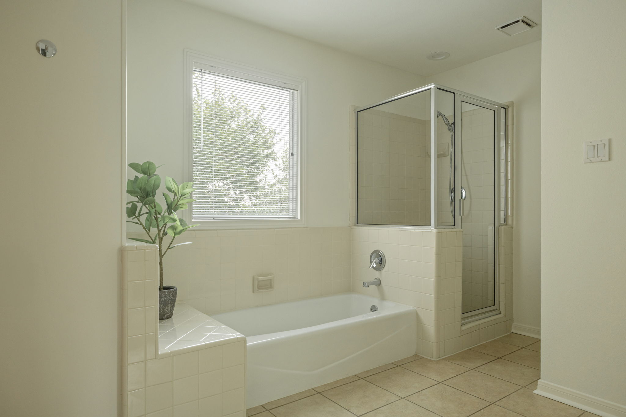 6010 Long Champ Court, Unit 113 Austin, TX 78746 - Photo 23 of 25 Bathroom with light tile patterned floors, a garden tub, and a stall shower