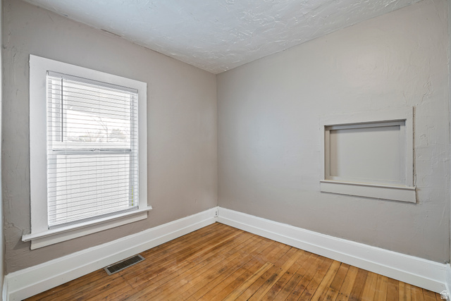 75 600 West Provo, UT 84601 - Photo 12 of 26 Interior room featuring wood-finish flooring, a double-hung window with blinds, and a built-in wall niche