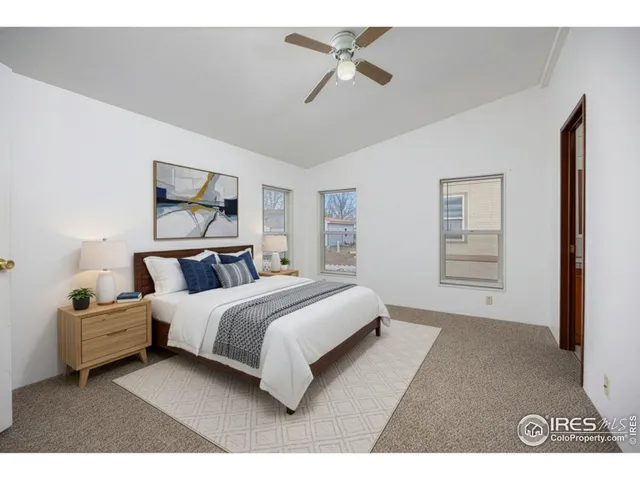 a spacious bedroom with a bed a window and a painting on the wall