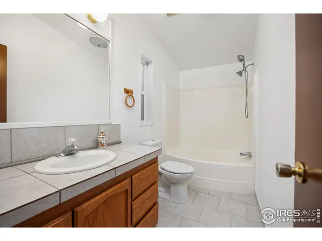 a bathroom with a sink a toilet a mirror and shower