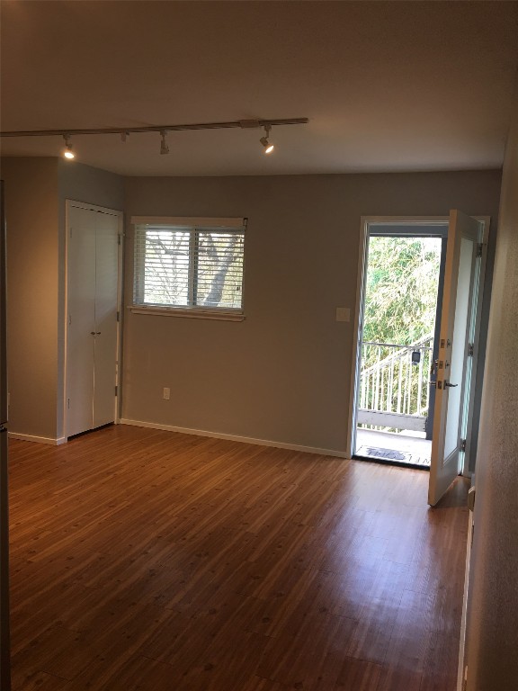 5306 Woodrow Avenue, Unit 204 Austin, TX 78756 - Photo 3 of 8 Unfurnished room with rail lighting and dark wood-style floors