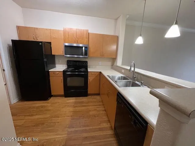 a kitchen with a sink a refrigerator and a stove top oven