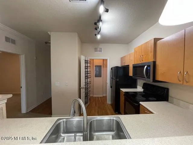 a kitchen with a sink and a refrigerator