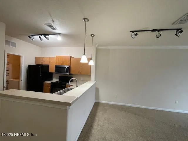 a view of a kitchen with a sink and refrigerator