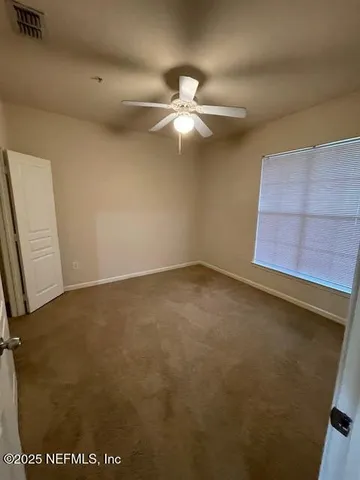 an empty room with closet and windows