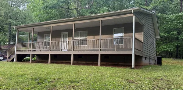 a view of house with backyard and front of trees