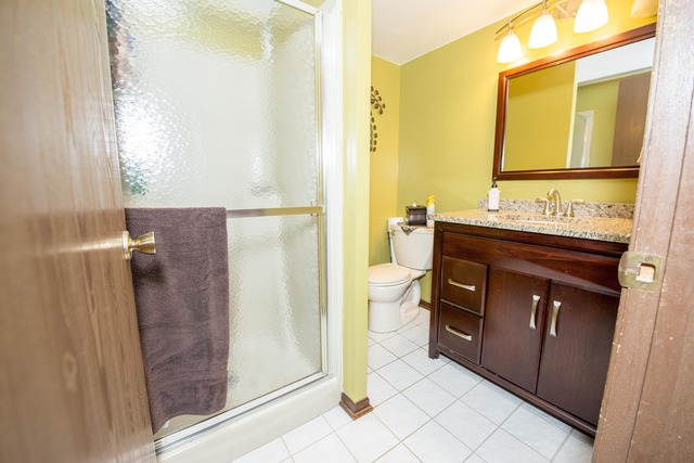 4 Wedgewood Road Matteson, IL 60443 - Photo 16 of 20 a bathroom with a granite countertop sink a mirror and a shower
