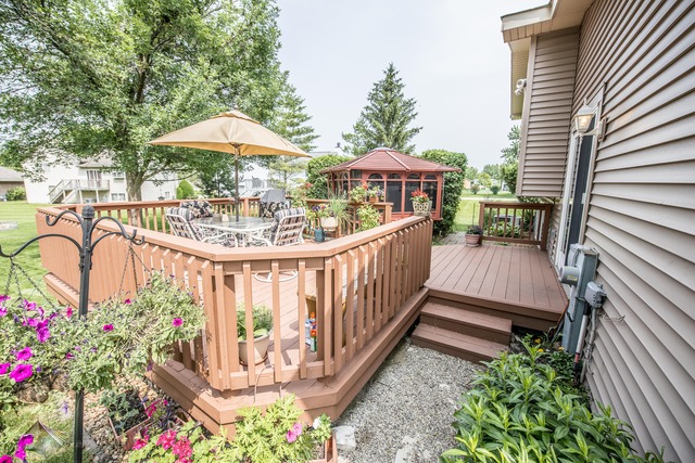 4 Wedgewood Road Matteson, IL 60443 - Photo 20 of 20 a view of a patio with a table and chairs under an umbrella with wooden fence