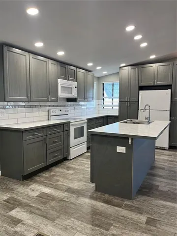 a kitchen with stainless steel appliances granite countertop a stove a sink dishwasher and a refrigerator