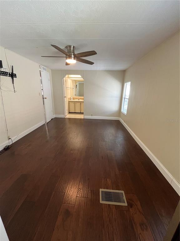 12100 Seminole Boulevard, Unit 365 Largo, FL 33778 - Photo 16 of 32 an empty room with wooden floor fan and windows
