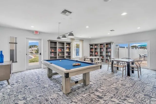 a room with furniture pool table and window