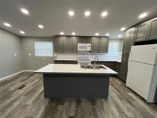 a kitchen with kitchen island a sink stainless steel appliances and cabinets