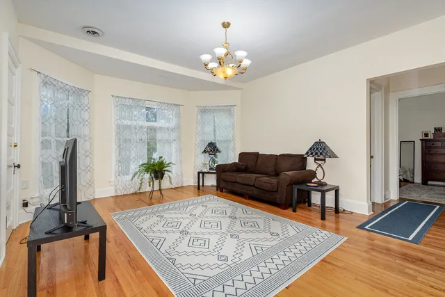 a living room with furniture a chandelier and a flat screen tv