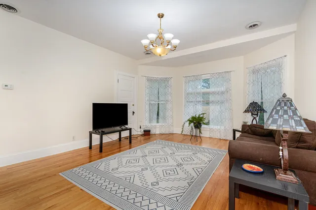 a living room with furniture and a chandelier