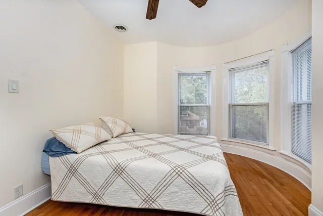 a bedroom with a bed and wooden floor