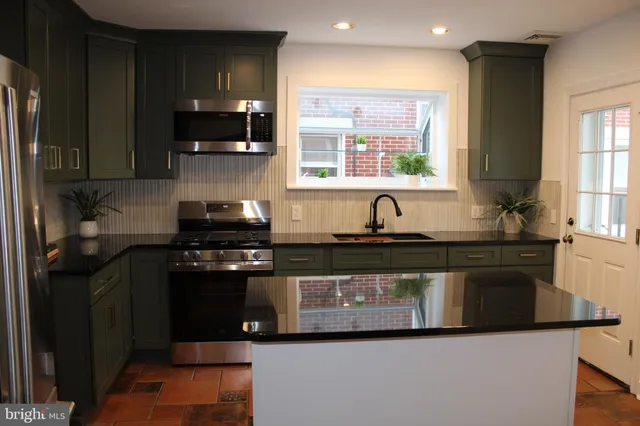 a kitchen with stainless steel appliances granite countertop a refrigerator and a stove top oven