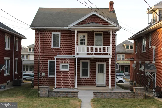 a view of a big house with a yard and plants