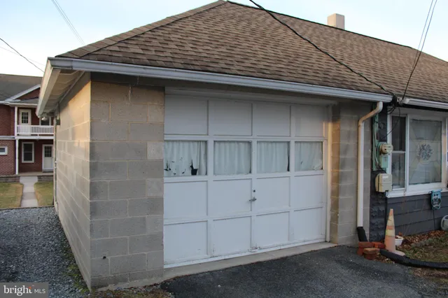 a view of a white house next to a yard